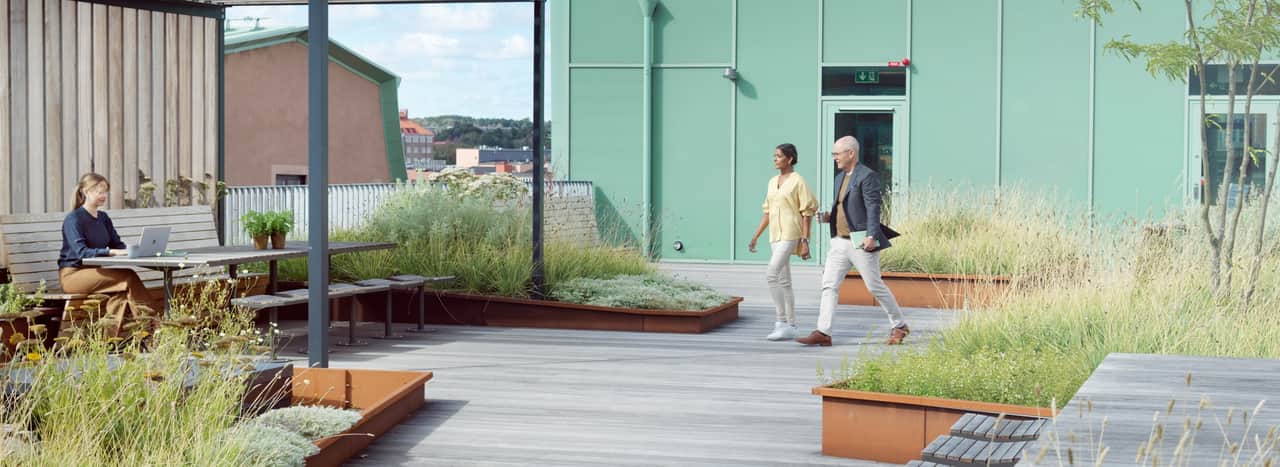 Two people walking through a kitchen area.
