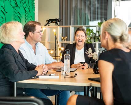 People sitting by a table laughing.