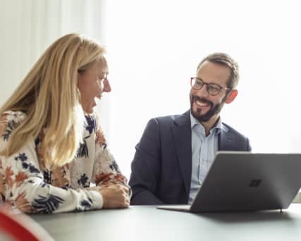 Two people laughing next to each other.