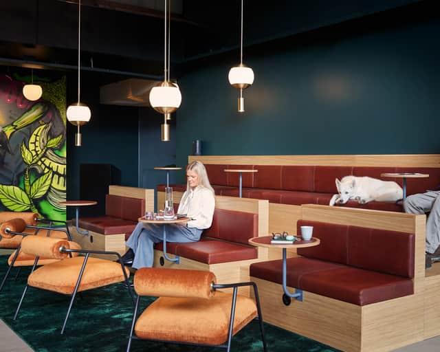 People and a dog sitting in a lounge area.