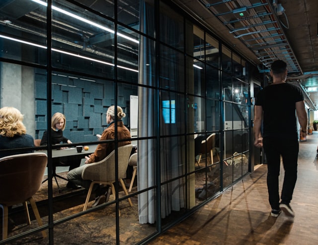 A man walking past a meeting room.