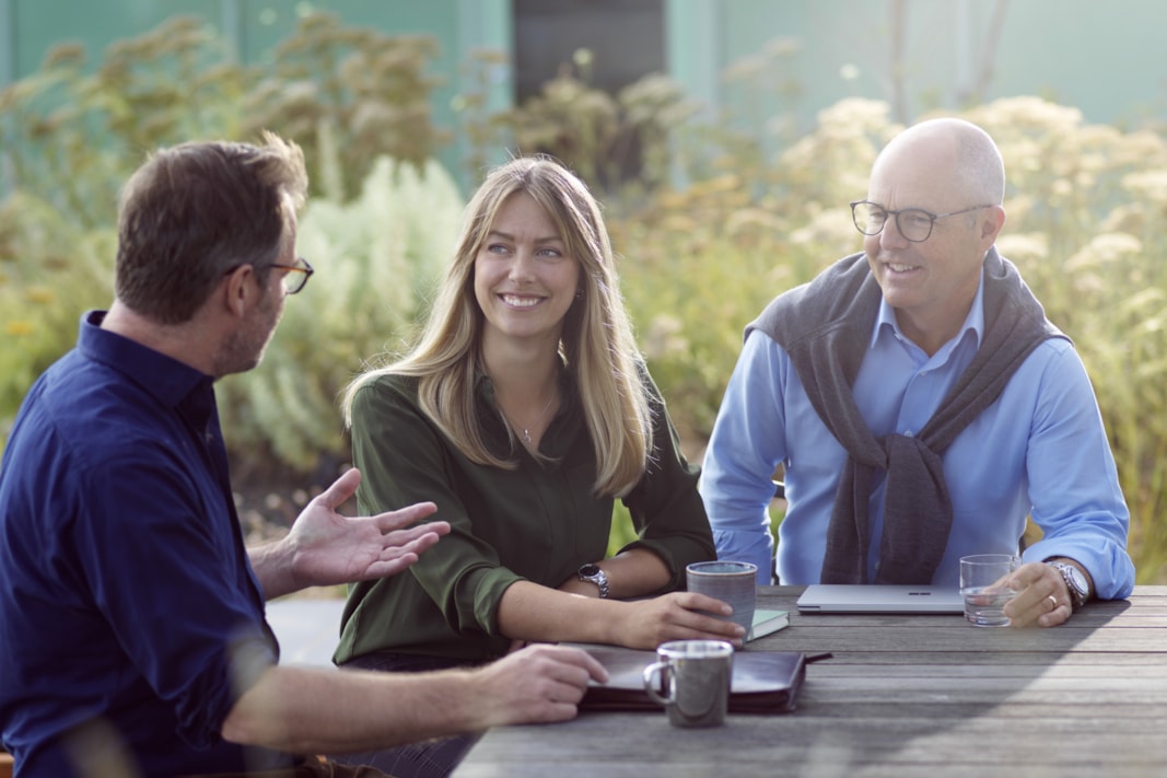 Three people having an outdoor meeting.