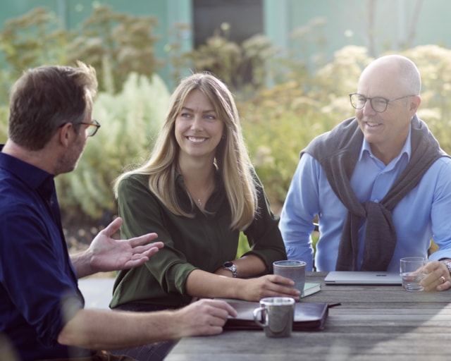 Three people having an outdoor meeting.