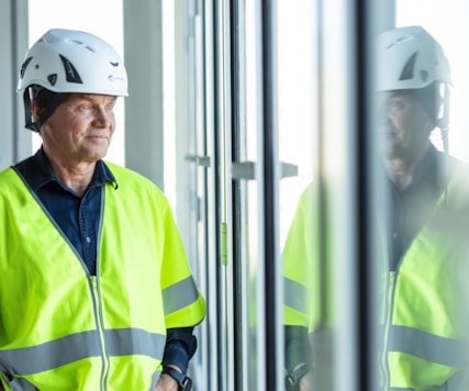 Person in protective wear looking out through a window,