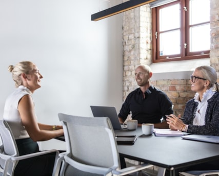 Three people sitting around a table.