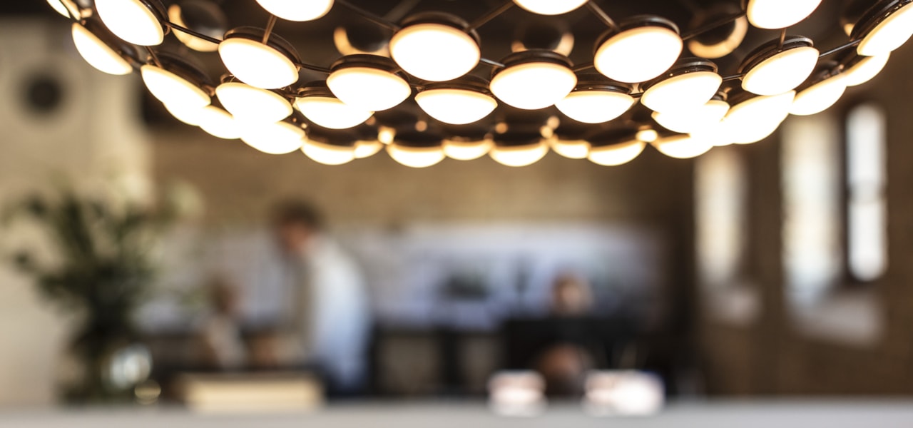 Closeup of a lamp with people in the background.