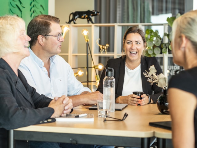 People sitting by a table laughing.