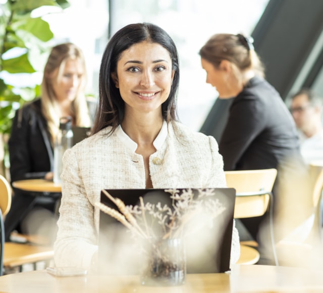 A person sitting by a computer smiling.