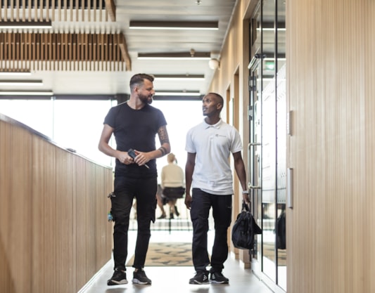 Two people walking in a hallway.