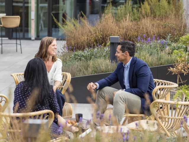 People sitting by a table outside.