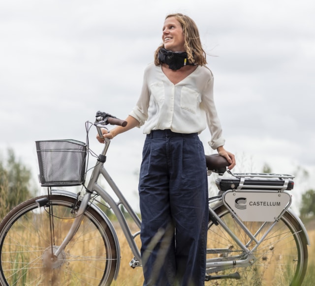 Person standing with a bike with the Castellum logo.