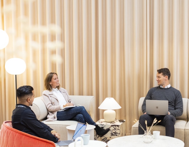 Three people sitting in a lounge area.