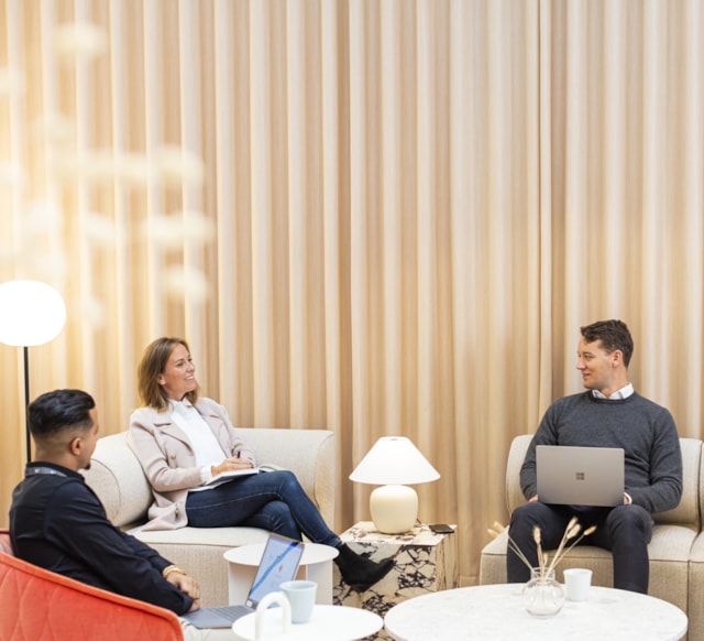 Three people sitting in a lounge area.