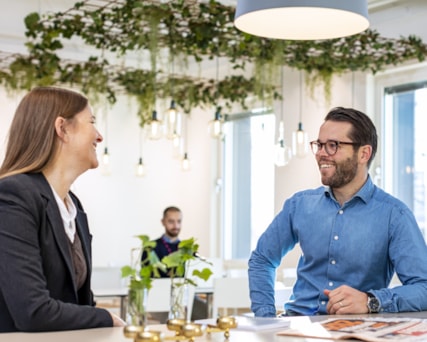 Three people working in a room with green walls.