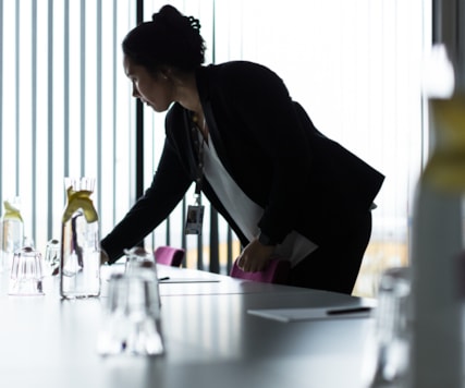 A service person preparing a conference table.