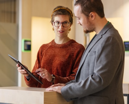 Two people looking at a screen device.