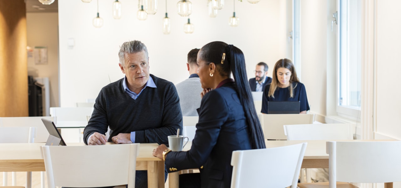 Two people sitting at a table talking.