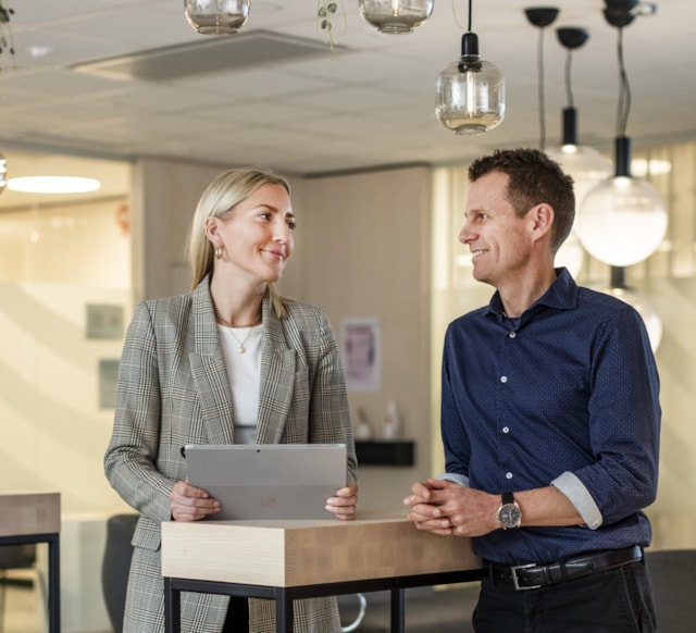 Two people standing by a table.