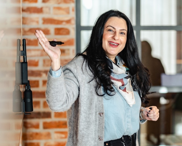 Office lady pointing towards a white board