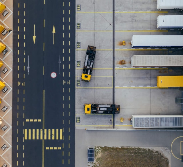 Overview of parking lot with road, warehouse and trucks