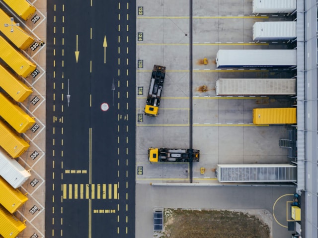 Overview of parking lot with road, warehouse and trucks