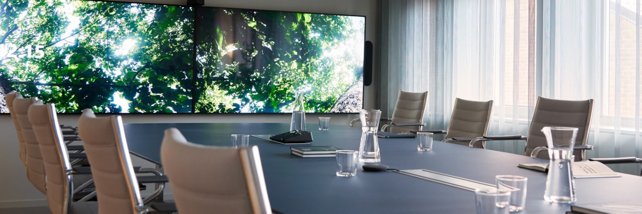 A conference room with at screen on the wall.