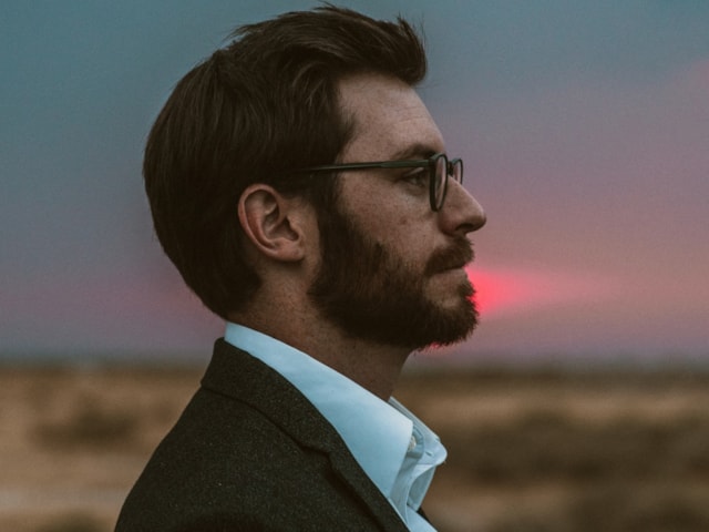 Close up picture of man with beard and dark hair